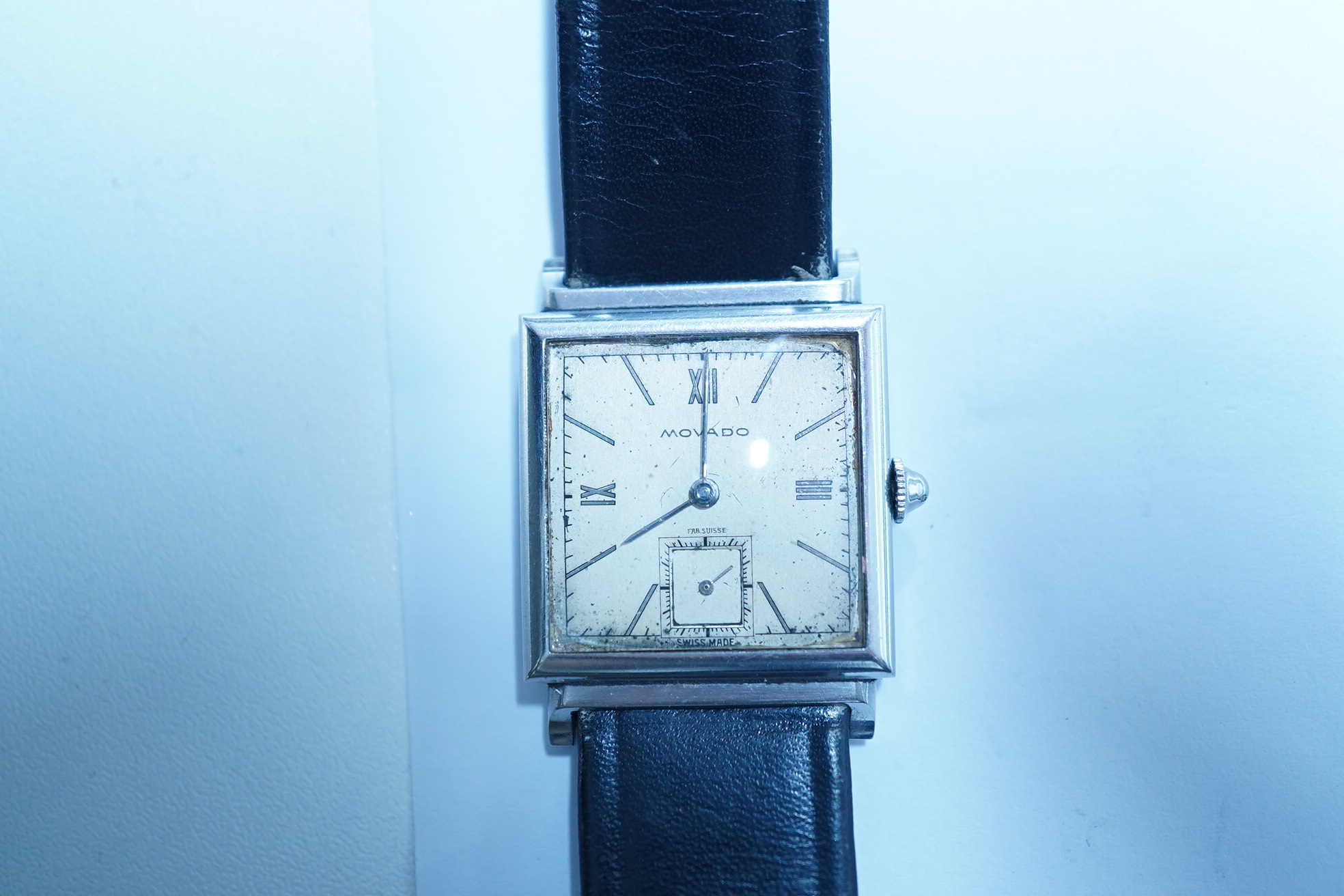 A gentleman's steel Movado manual wind square dial wrist watch, with Roman and baton numerals and subsidiary seconds, case diameter 25mm, on a later associated leather strap. Condition - poor